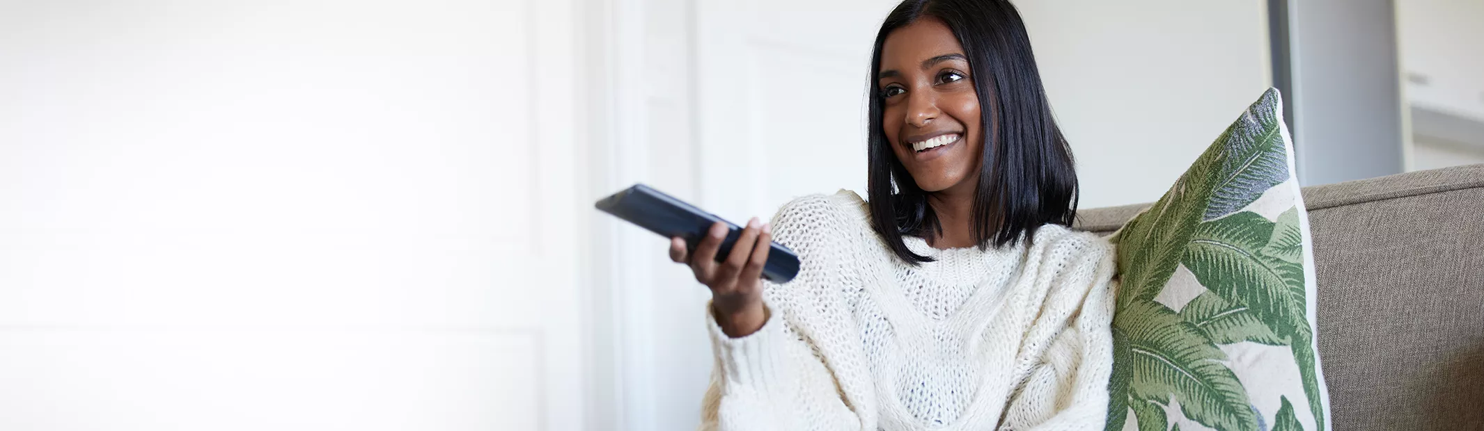 Woman pressing TV remote buttons