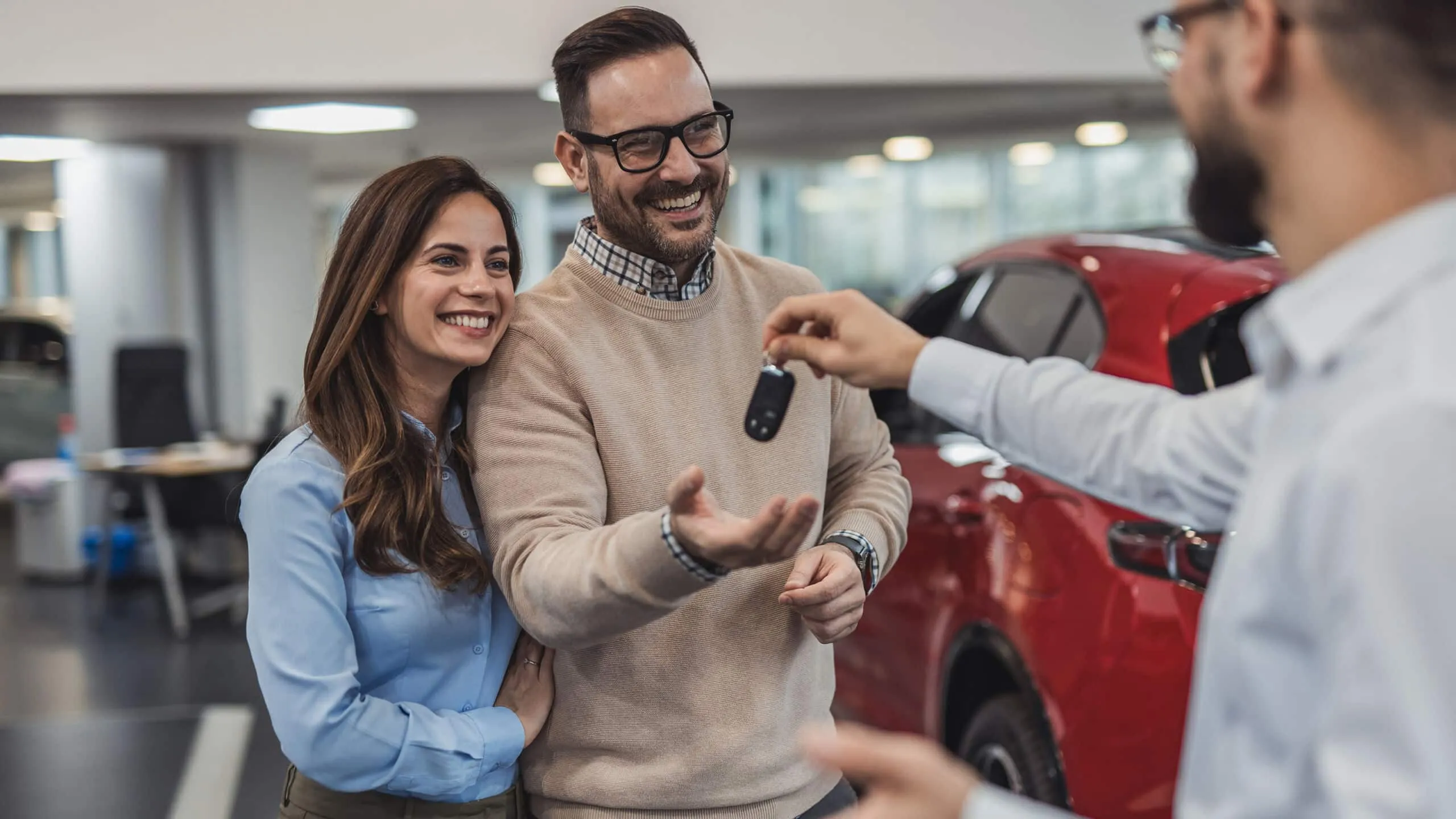 Couple receiving new car keys at dealership