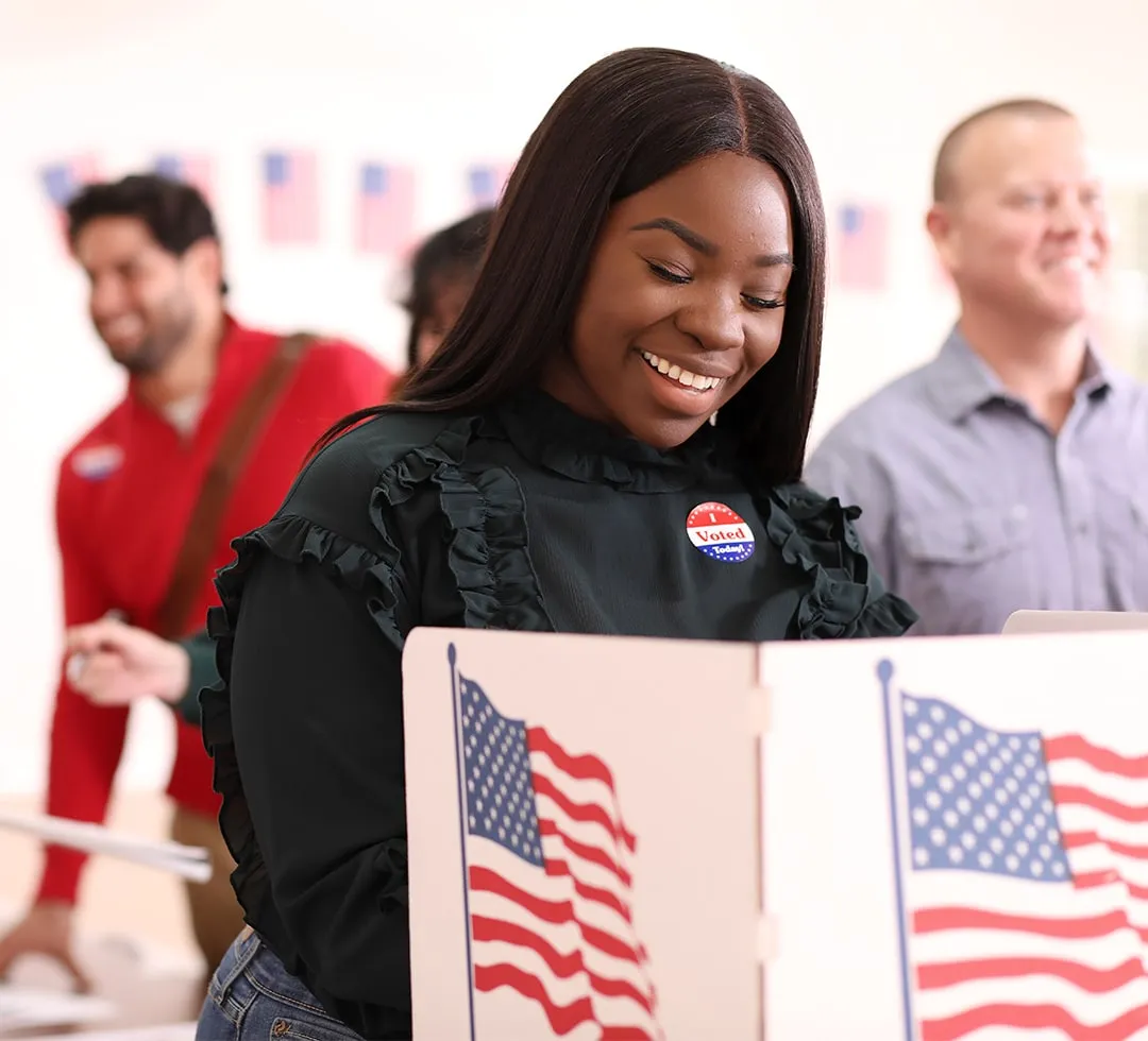 Women with I Voted sticker at voting booth