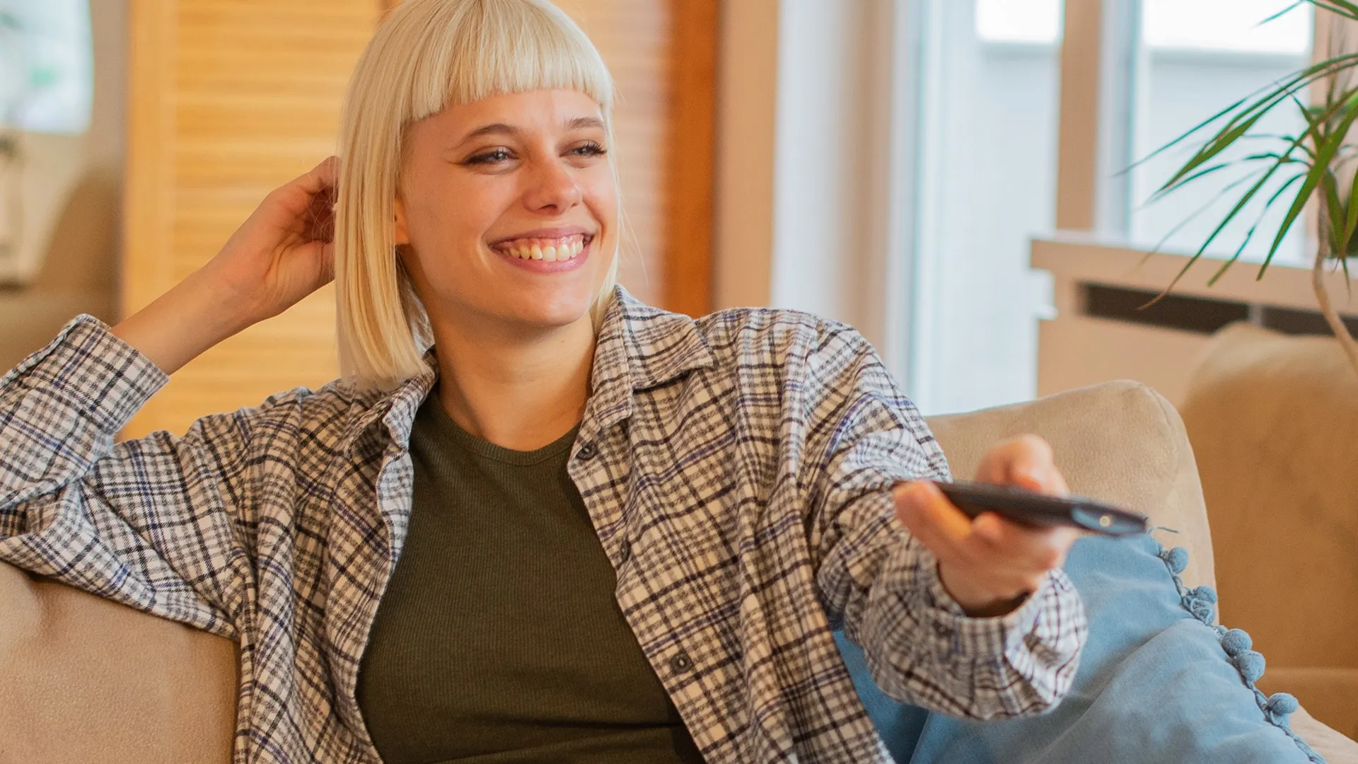 Woman sitting down using a TV remote