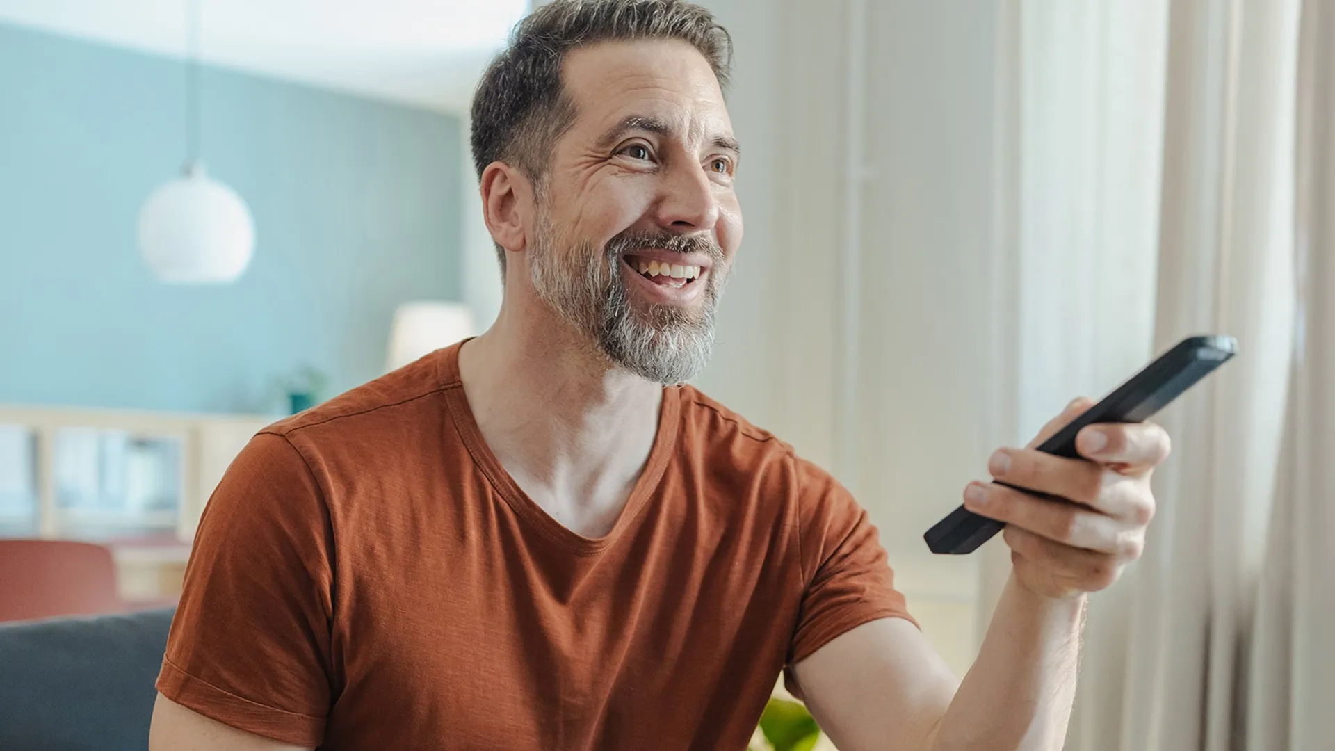 Man smiling using a tv remote
